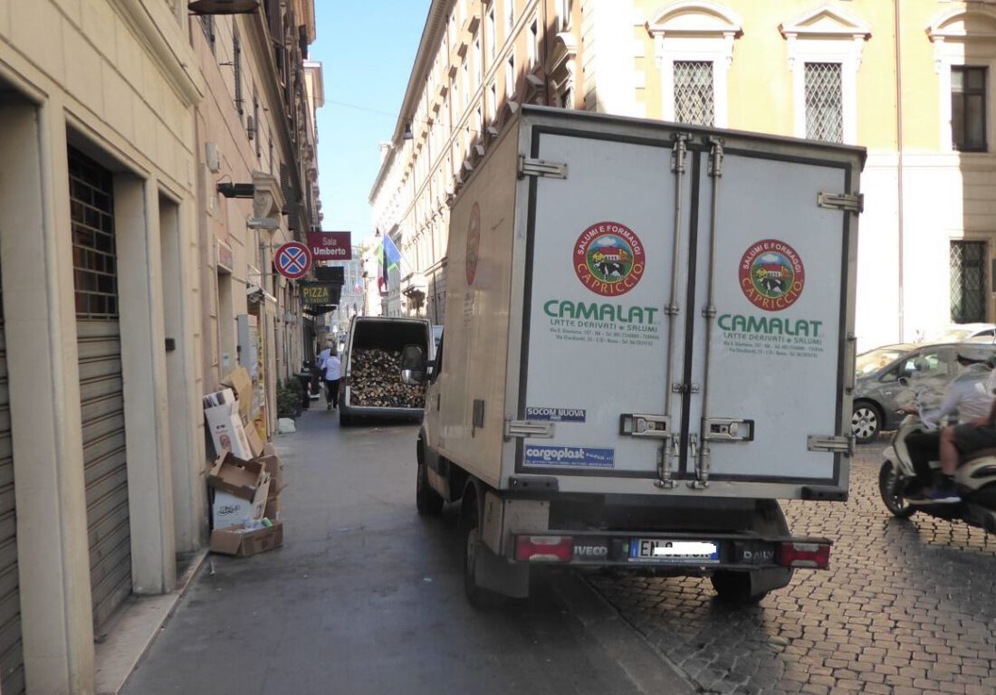 Due furgoni per lo scarico merci parcheggiati sul marciapiede in centro a Roma