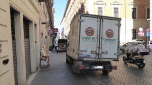 Due furgoni per lo scarico merci parcheggiati sul marciapiede in centro a Roma