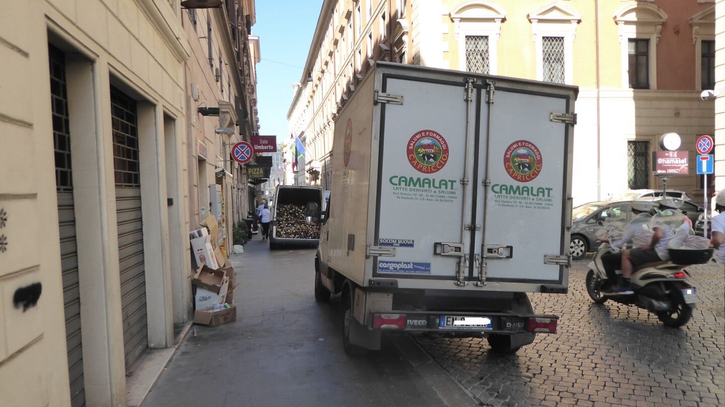 Due furgoni per lo scarico merci parcheggiati sul marciapiede in centro a Roma